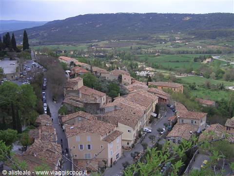 Village with terracotta roofs surrounded by green hills and farmland