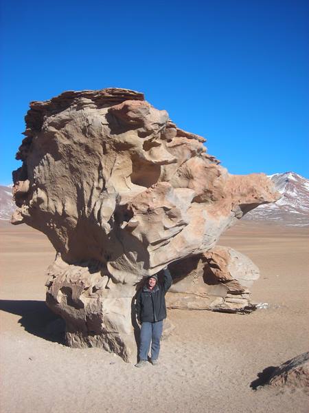 Traveler under the Árbol de Piedra, wind-carved rock in the desert
